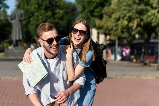 Pareja de turistas sonrientes posando juntos al aire libre