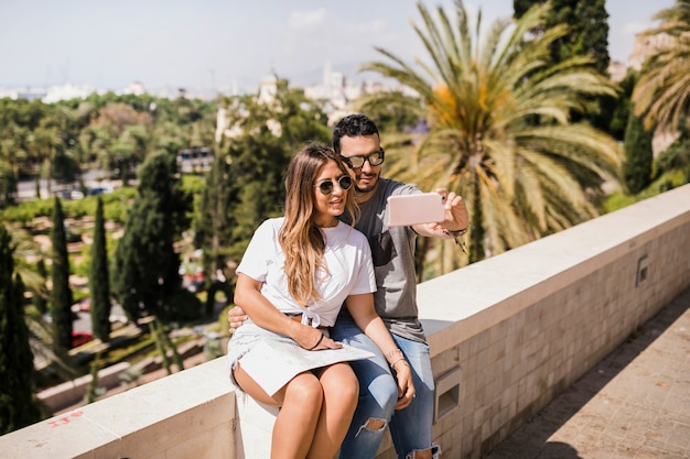 Foto gratuita pareja de turistas tomando autorretrato en el teléfono celular