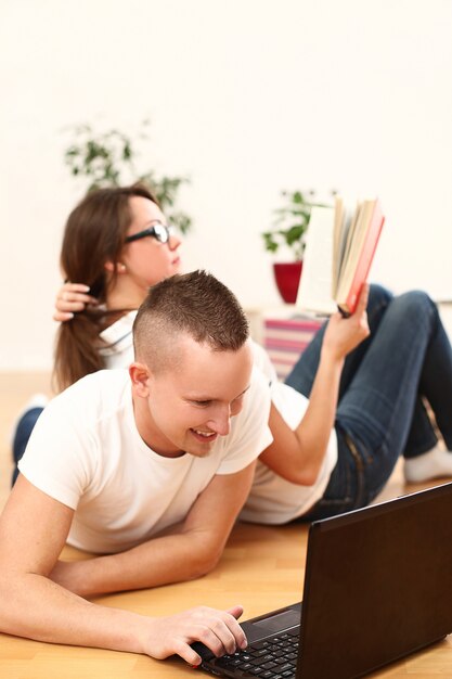 pareja usando laptop y lectura