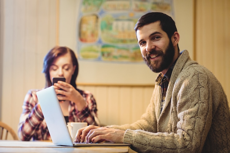Foto gratuito pareja usando laptop y teléfono móvil