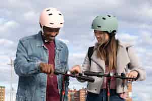 Foto gratuita pareja usando scooter eléctrico para transporte