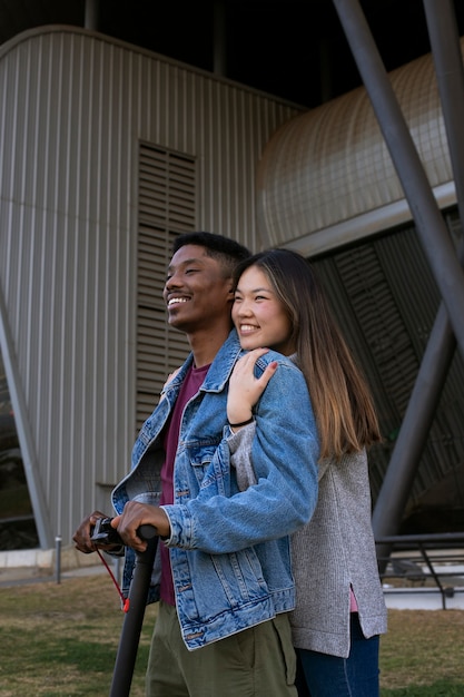 Foto gratuita pareja usando scooter eléctrico para transporte