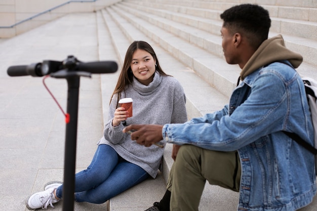 Foto gratuita pareja usando scooter eléctrico para transporte