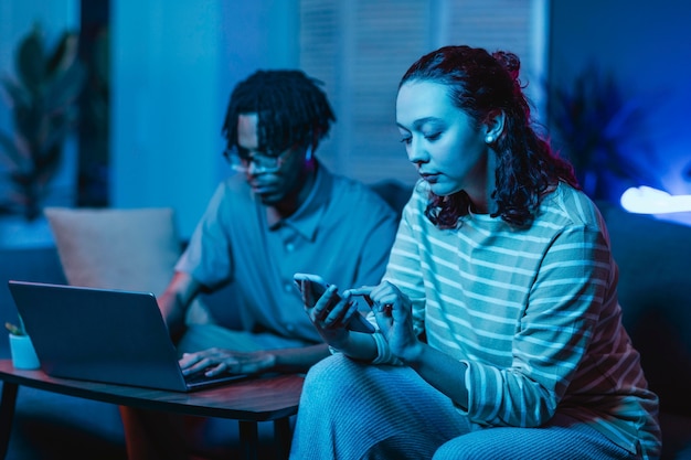 Pareja usando sus dispositivos modernos en casa juntos