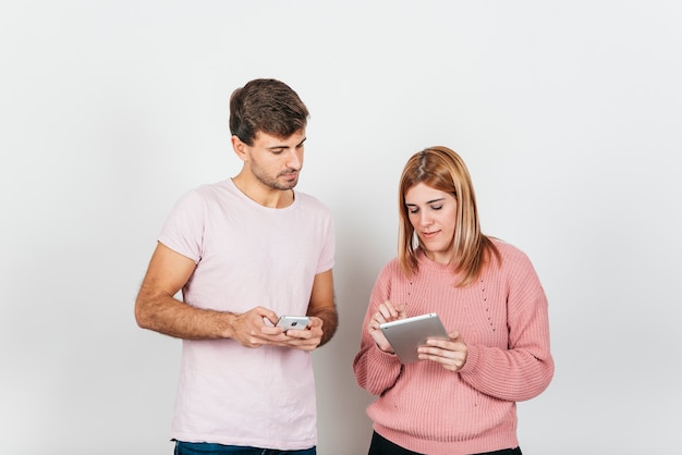 Pareja usando tableta y teléfono