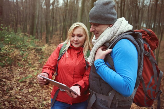 Pareja usando tecnología inalámbrica en el bosque