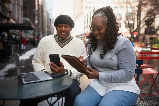 Foto gratuita pareja usando tecnología mientras viaja por la ciudad