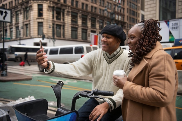 Foto gratuita pareja usando tecnología mientras viaja por la ciudad