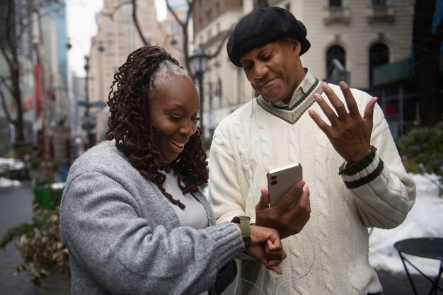 Foto gratuita pareja usando tecnología mientras viaja por la ciudad