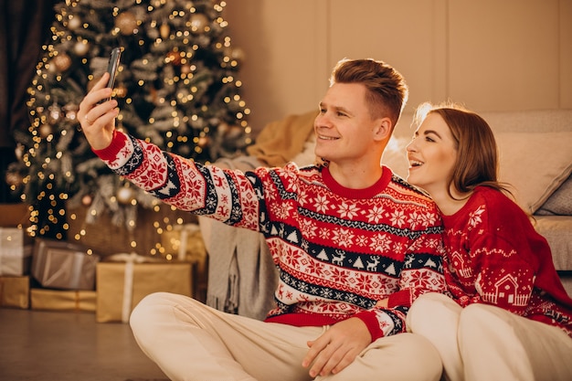 Pareja usando el teléfono juntos en Navidad