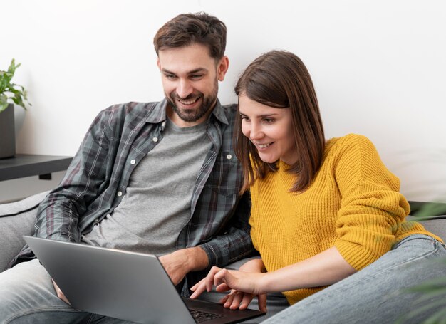 Pareja, usar la computadora portátil, en casa