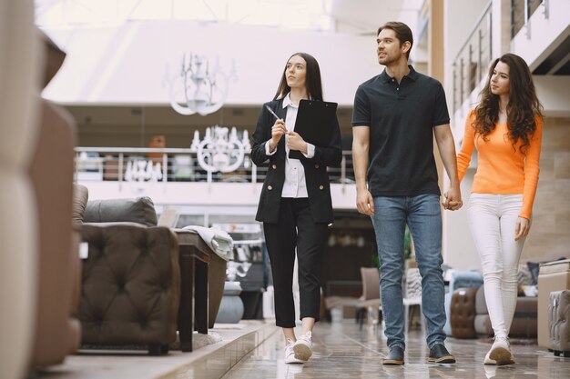 Pareja con vendedor en tienda de muebles