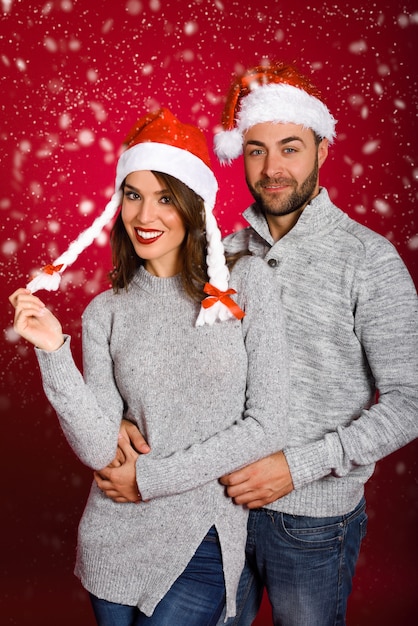 Foto gratuita pareja vestida con ropas de inviero y sombrero de papa noel
