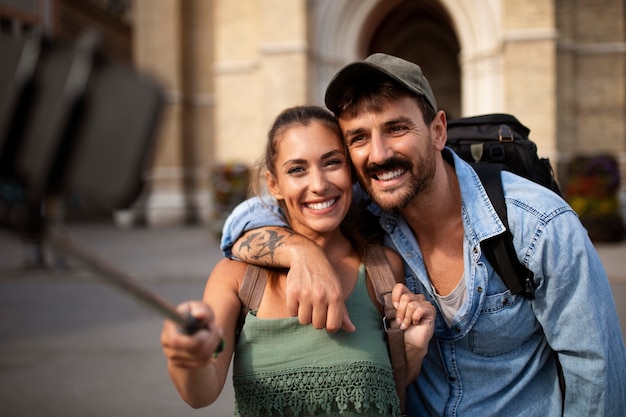 Foto gratuita pareja viajando y tomándose selfie juntos en la ciudad