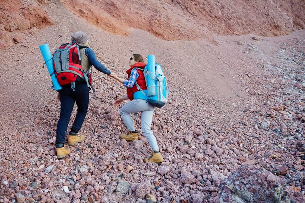 Pareja de viajeros escalando montañas