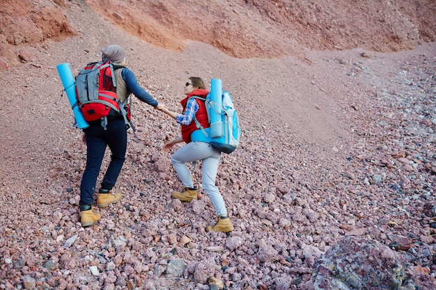 Pareja de viajeros escalando montañas