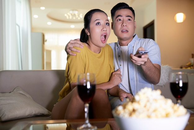 Pareja viendo películas de terror en casa