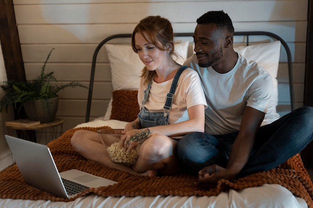 Pareja viendo servicio de streaming juntos en el dormitorio