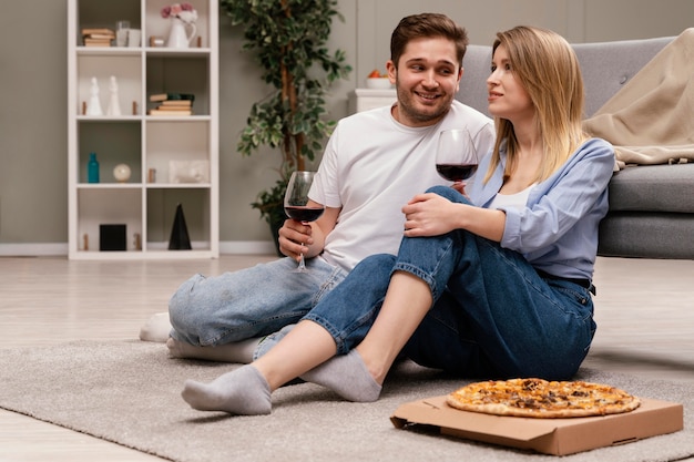 Pareja viendo la televisión y bebiendo vino