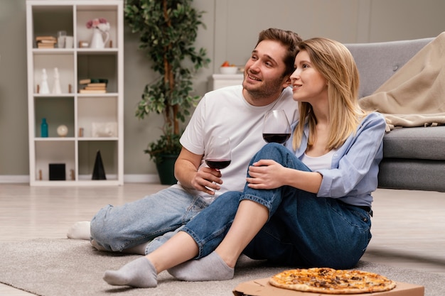 Pareja viendo la televisión y bebiendo vino