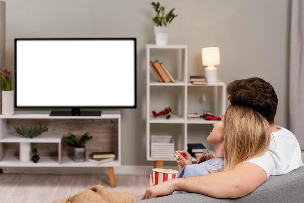 Pareja viendo la televisión y comiendo palomitas de maíz