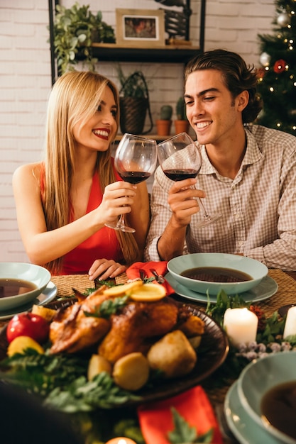 Foto gratuita pareja con vino en cena de navidad