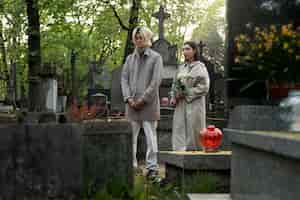 Foto gratuita pareja visitando una tumba juntos en el cementerio