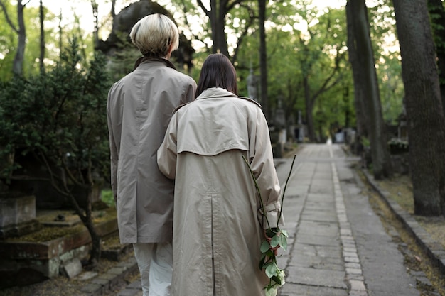 Foto gratuita pareja visitando una tumba juntos en el cementerio