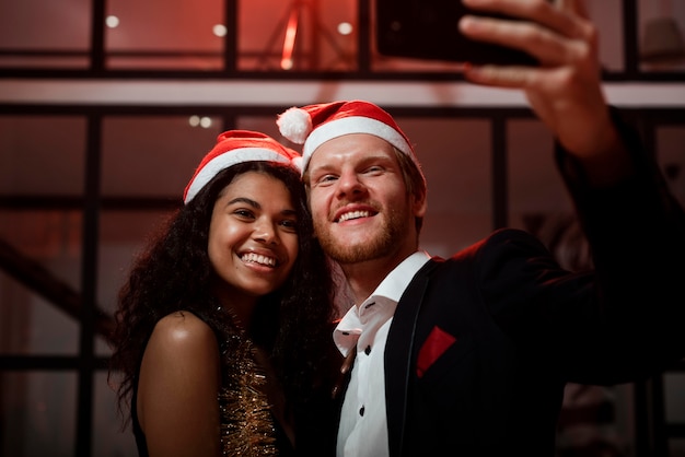 Pareja de vista frontal tomando un selfie en la fiesta de fin de año