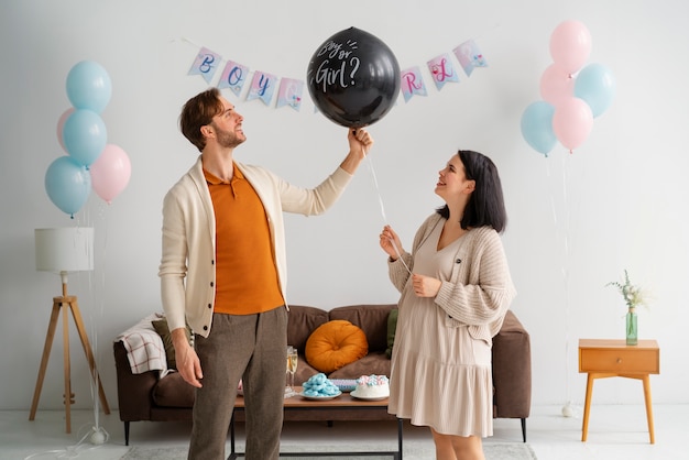 Foto gratuita pareja de vista lateral en fiesta de revelación de género