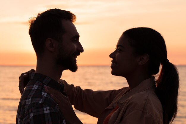 Pareja de vista lateral mirando el uno al otro al atardecer