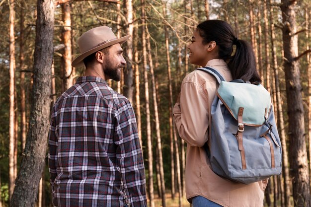 Pareja de vista posterior dando un paseo por el bosque