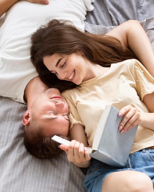 Foto gratuita pareja de vista superior leyendo juntos un libro