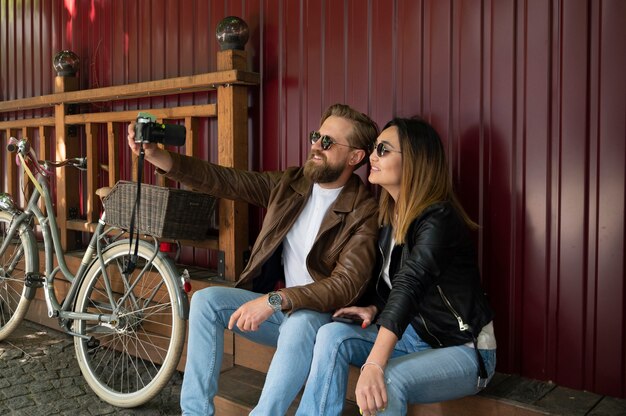 Pareja vistiendo chaquetas de cuero sintético tomando selfie juntos al aire libre