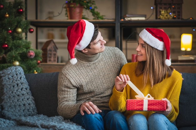 Pareja vistiendo suéteres con regalo