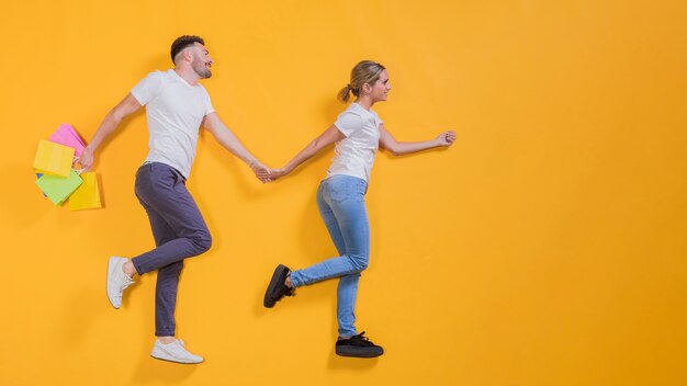 Pareja volando con bolsas