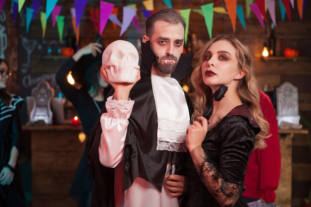 Pareja wounderful en disfraces de halloween en una fiesta. Hombre disfrazado de Drácula para la celebración de halloween.