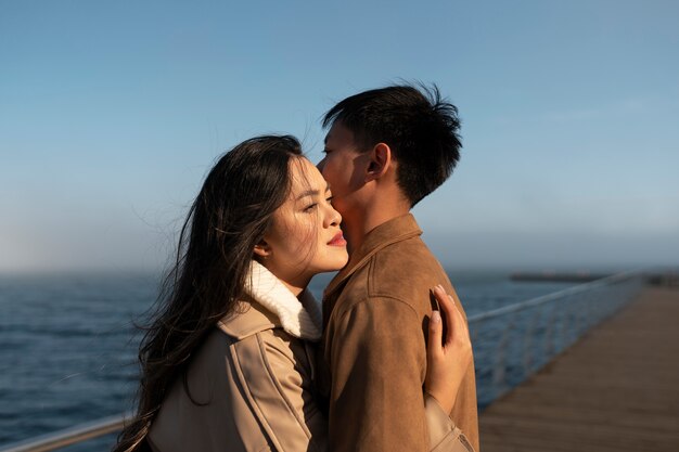 Parejas abrazándose cerca del mar