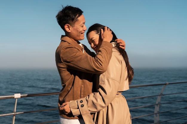 Foto gratuita parejas abrazándose cerca del mar