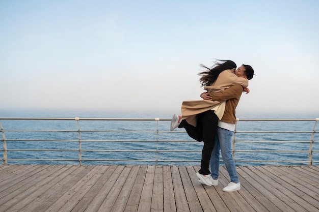 Parejas abrazándose cerca del mar