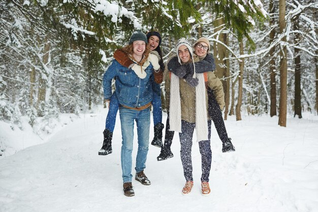 Parejas divirtiéndose en el bosque de invierno