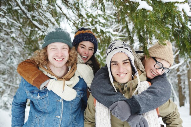 Parejas felices en bosque de invierno