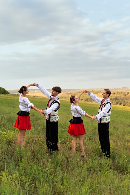 Parejas jóvenes de tiro completo bailando al aire libre