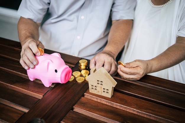 Parejas mayores hablando de finanzas con alcancía