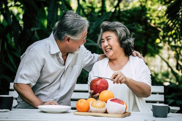 Parejas mayores jugando y comiendo algo de fruta