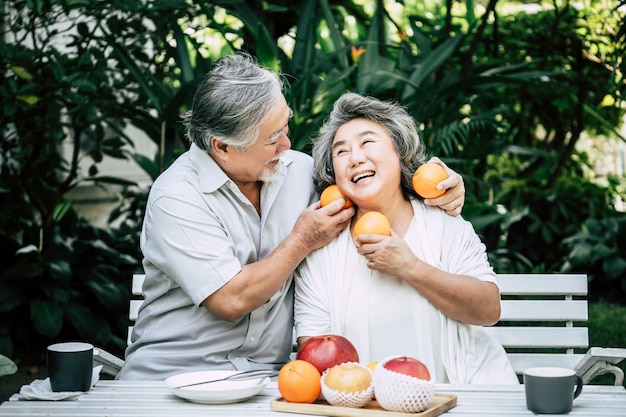 Parejas mayores jugando y comiendo algo de fruta