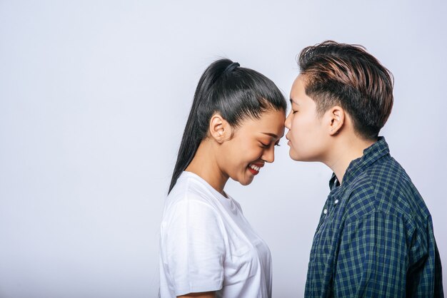 Parejas de mujeres de pie y mejillas fragantes.