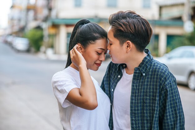 Parejas de mujeres de pie y mejillas fragantes.