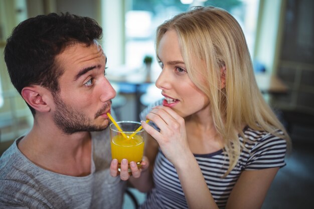 Pares que tienen un vaso de zumo de naranja