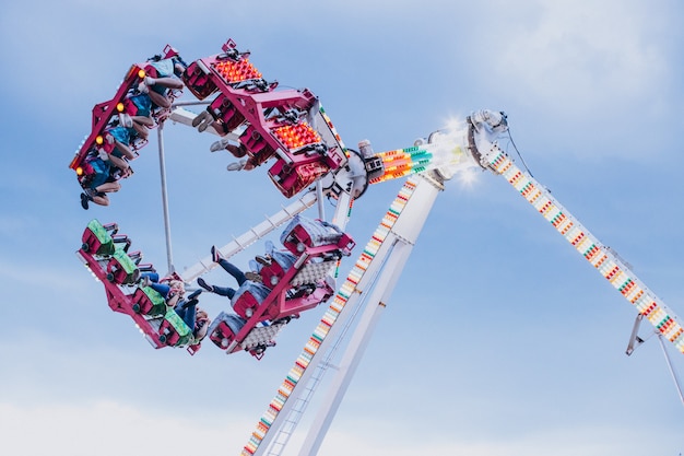 Parque de atracciones con atracción ecuestre lleno de gente.